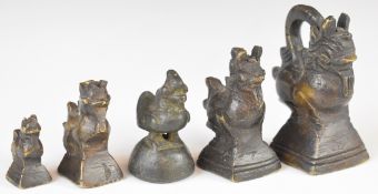 Five opium weights comprising one set of four and a further example formed as a bird, height of