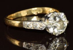 An 18ct gold ring set with a diamond of approximately 1.1ct in a platinum setting, with further