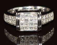 An 18ct white gold ring set with sixteen princess cut blue diamonds, the head of the ring rotating