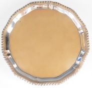 George V hallmarked silver card tray with shaped gadrooned edge, raised on three ball and claw feet,