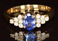 An 18ct gold ring set with an oval cut tanzanite of approximately 0.6ct and diamonds, 4.6g, size O