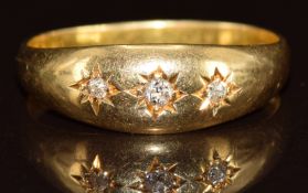 A c1900 18ct gold ring set with three diamonds in star settings, 3.4g, size O