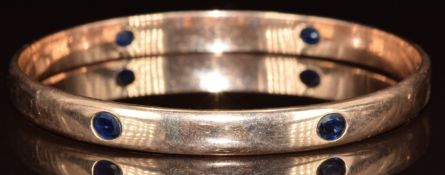 A 9k gold bangle set with six oval cut sapphires, each approximately 0.35ct, 23.1g, 6.1cm