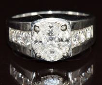 A platinum ring set with princess and marquise cut diamonds in a round cluster, and six round cut