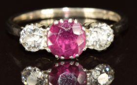 An 18ct white gold ring set with a round cut ruby of approximately 0.75ct and two diamonds, each