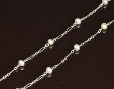 A c1915 9ct white gold necklace made up of oval and elongated links and beaded pearls with a