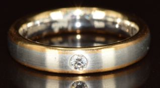 A platinum and 18ct gold wedding band/ ring with matt finish set with a diamond, 8.1g, size M