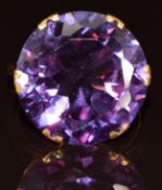 A yellow metal ring set with a round cut synthetic purple sapphire (18.5mm), 9g, size O (tests as