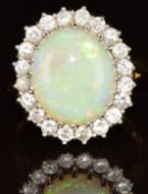 An 18ct gold ring set with an oval opal cabochon (13.9 x 12mm) surrounded by twenty round cut