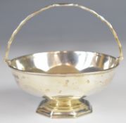 George V hallmarked silver swing handled basket or bon bon dish, raised on an octagonal foot,