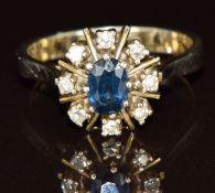 A 14k gold ring sett with an oval sapphire of approximately 0.5ct and eight round cut diamonds, 3.
