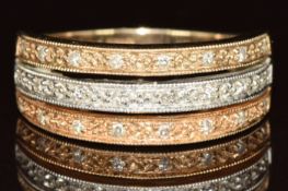 A 9ct gold bi-coloured ring set with diamonds in three rows, 4.3g, size Q