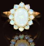 A 9ct gold ring set with an oval opal cabochon surrounded by round opal cabochons, 2.7g, size P