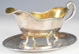 German silver sauce boat on stand, the sauce boat having gilt interior and raised on four paw