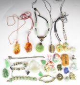 A collection of Chinese jade, jadeite and similar pendants one in the form of a boat and another