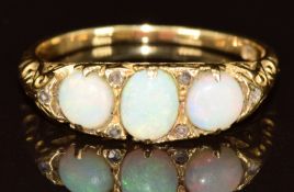 A c1900 18ct gold ring set with three opal cabochons and six rose cut diamonds, 3.5g, size P