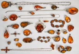 A collection of silver and amber jewellery including two brooches, twenty pendants, four rings,