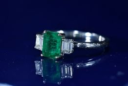 An 18ct white gold ring set with an emerald cut emerald of approximately 1.29ct and two emerald