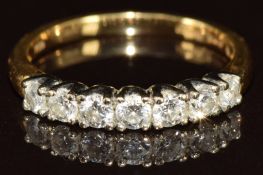 An 18ct gold ring set with seven graduated round cut diamonds measuring 0.05-0.08ct, 2.6g, size L