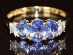 An 18k gold ring set with three oval cut tanzanites and diamonds, 3g, size P