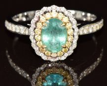 A 14k white gold ring set with an oval cut emerald of approximately 1.3ct surround by eighteen