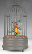 Pair of automaton singing birds in cage with clockwork mechanism to base, overall height 26.5cm