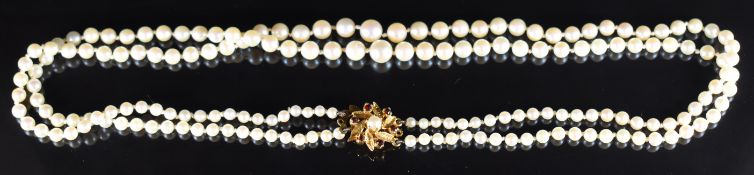 A double strand of cultured pearls, the 9ct gold clasp set with a pearl and garnets 26.5g, 44cm