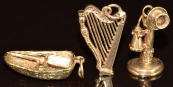 Three 9ct gold charms / pendant in the form of a rowing boat, harp and telephone, 8.6g