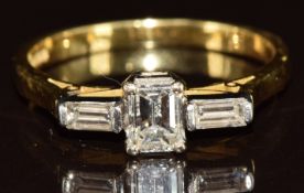 An 18ct gold ring set with an emerald cut diamond of approximately 0.5ct and two baguette cut