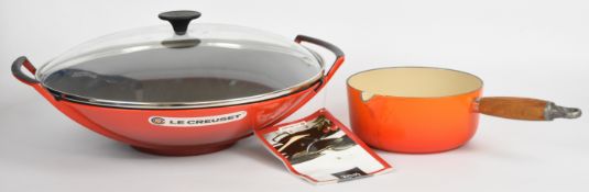 Le Creuset covered wok, unused with tag still attached, and an orange number 18 saucepan, wok
