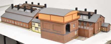 Four kit built 0 gauge model railway buildings comprising two engine sheds, coaling stage and signal
