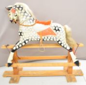 20th century rocking horse with painted body and leather straps, overall length 137cm