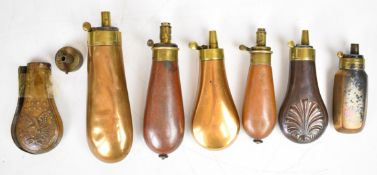 Seven copper and brass powder flasks including Colt revolver/ pistol style bag shaped, G&JW Hawksley