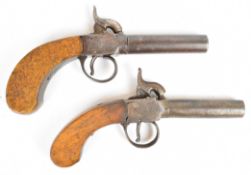 A near pair of percussion hammer action pocket pistols each with shaped wooden grip and 3 inch