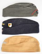 Three German military caps with printed marks, 'August Schellenberg, 1942', 'Berolina 1941', and '
