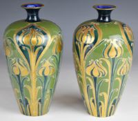 Matched pair of William Moorcroft Macintyre Florian Ware vases decorated in the green and gold Tulip