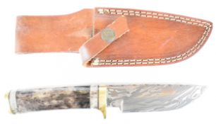 Unnamed hunting knife with horn or similar and brass handle and 12cm Damascus blade, in leather