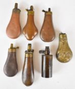 Seven pistol or revolver powder flasks including a Colt style bag shaped example, one with