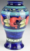 William Moorcroft Art Deco baluster vase decorated in the banded Pomegranate pattern; signed and