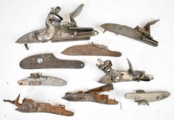 Nine flintlock locks and lock plates including two stamped 'Tower' and 'GR', largest 17.5cm long.