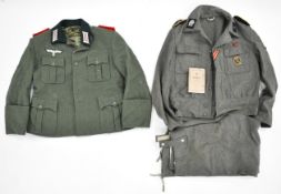 Two reproduction German military uniforms, one printed with 'SS / BW' mark to lining