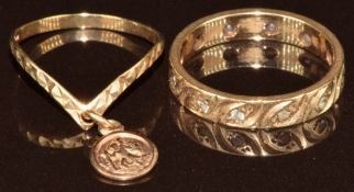 A 9ct gold eternity ring and a 9ct gold 'V' shaped ring with a St Christopher pendant drop, 2.8g,