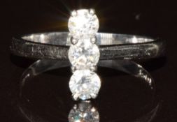 A platinum ring set with three round cut diamonds totalling approximately 0.4ct, 2.9g, size H