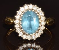 An 18ct gold ring set with an oval cut topaz surrounded by diamonds, 5.3g, size K/L