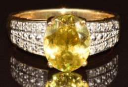 An 18k gold ring set with an oval cut sphene of approximately 2.5ct and diamonds, with