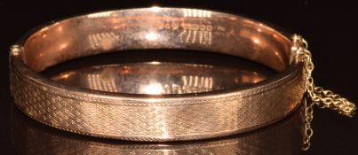 A 9ct gold bangle with patterned decoration, Birmingham 1937, 11.2g