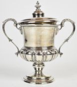 George V hallmarked silver lidded twin handled trophy cup with acanthus leaf decoration to the