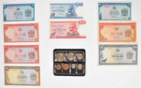 Nine Rhodesia and Zimbabwe banknotes 1974-1980 and a set of uncirculated Rhodesia coins 1970-1976,