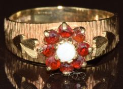 A 9ct gold ring set with an opal surrounded by garnets, size O