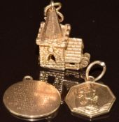 Three 9ct gold charms, a church opening to reveal a wedding ceremony, a St Christopher and one